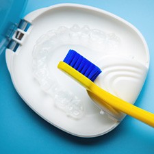 Transparent aligners in a case next to a toothbrush