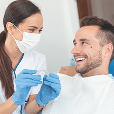 A dentist showing an Invisalign tray to her patient