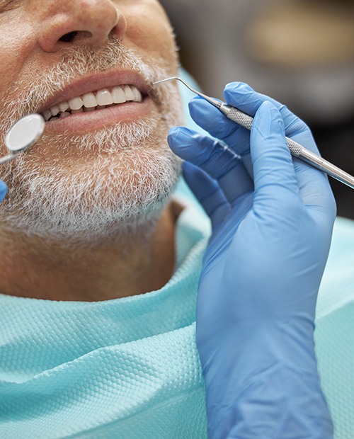 An elderly man receiving a brief oral exam