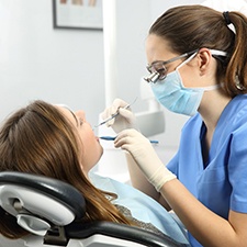 A dentist examining a woman’s teeth during a dental checkup