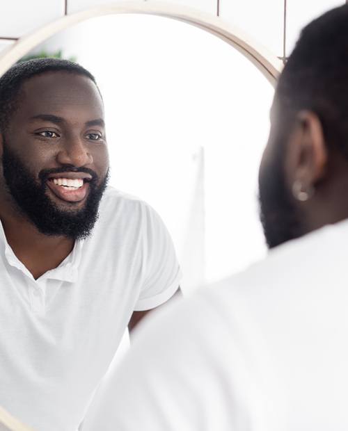 a man looking in a bathroom mirror