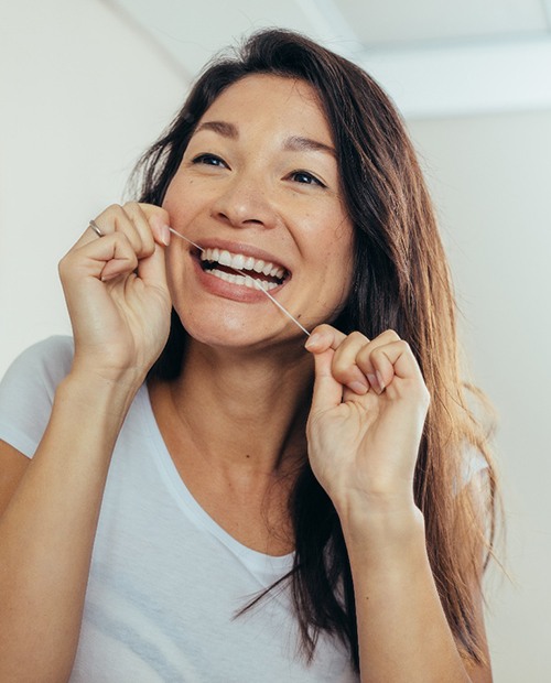 a woman flossing her teeth