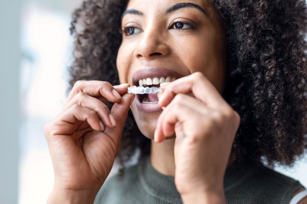 Woman with curly hair inserting Invisalign